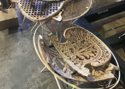 A pair of wrought iron latticed tables that have not yet been abrasive blasted. These to are a part of the home pick up and delivery service offered by Hartech