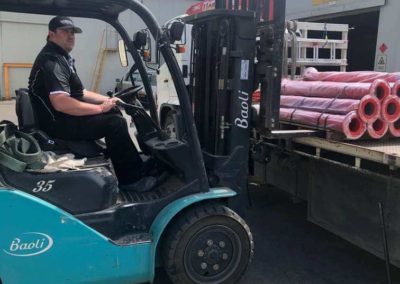 Sections of Gas pipe that have been restored being loaded onto a Hartech truck for delivery